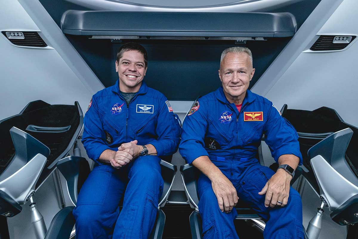 NASA astronauts, from left, Bob Behnken and Doug Hurley, assigned to fly on SpaceX's Demo-2 test flight of its Crew Dragon, are inside a mockup of the spacecraft at NASA's Johnson Space Center in Houston on Aug. 2, 2018, ahead of the agency's announcement of their commercial crew assignment.