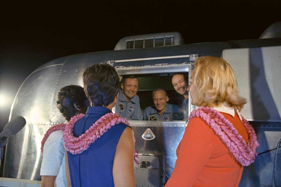 The Apollo 11 crewmen, still under a 21-day quarantine, are greeted by their wives.