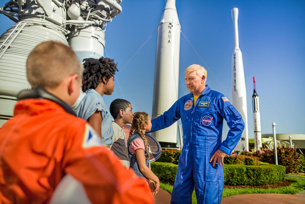 Guests touring the Rocket Garden with Astronaut Jon McBride at Kennedy Space Center Visitor Complex.