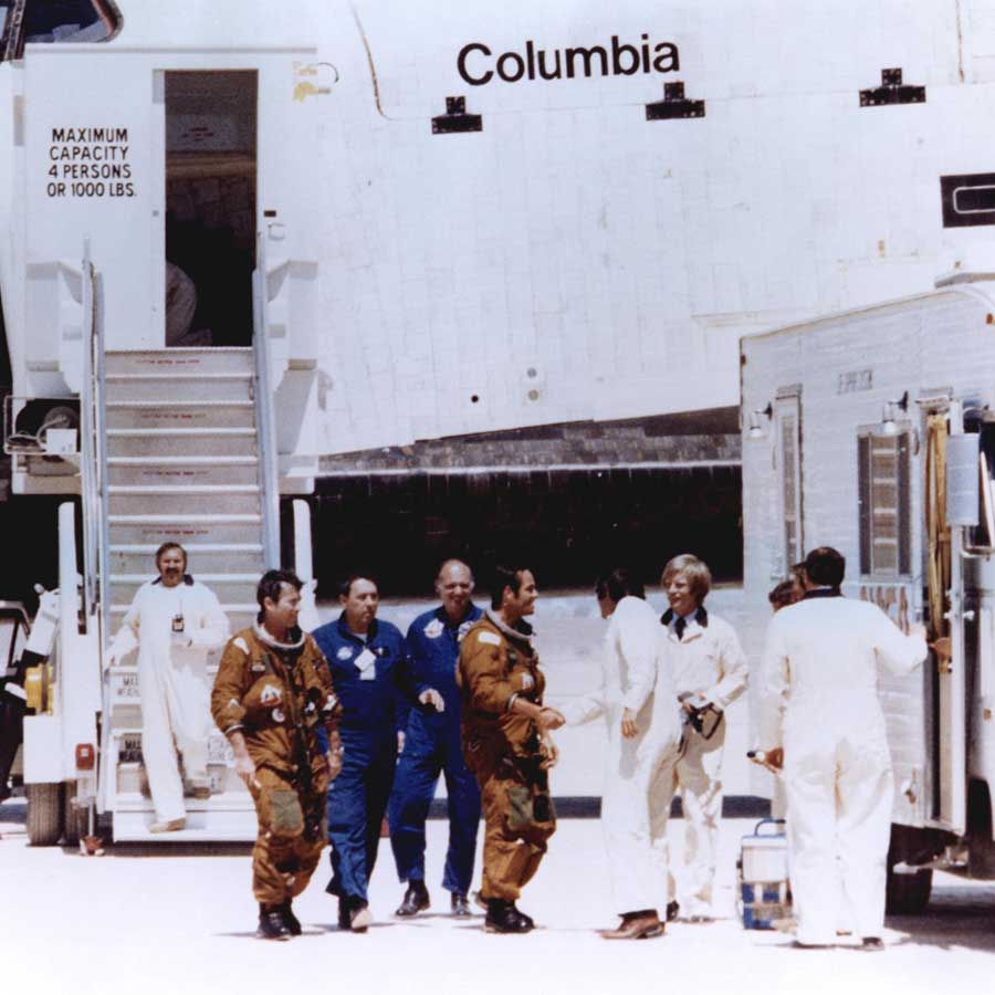 Space Shuttle astronauts John Young and Robert Crippen (in tan space suits) are greeted by members of the ground crew moments after stepping off the shuttle Columbia following its first landing at Edwards Air Force Base, Calif. Young and Crippen had piloted the Columbia on its first orbital space mission, April 12 - 14, 1981.